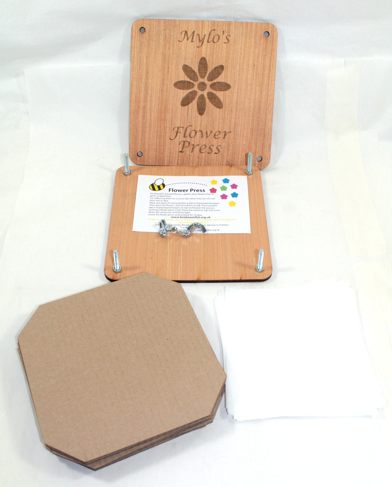 open flower press with cardboard sheets and leaflet